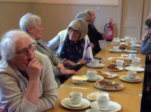 people talking, drinking tea and eating cake