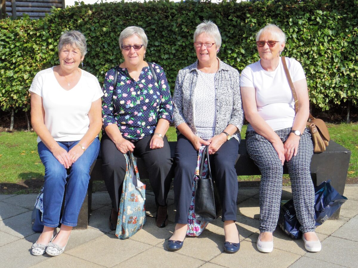 four people sitting in the sunshine